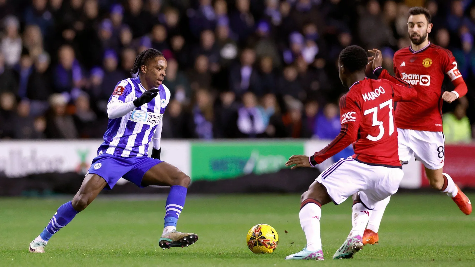 Martial Godo thi đấu cho Wigan Athletic đối đầu Manchester United